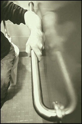 Diagram showing ADA-compliant grab bar mounted behind a toilet